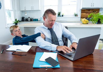 Wall Mural - COVID-19 school lockdowns and remote working. Stressed man trying to work from home with bored son