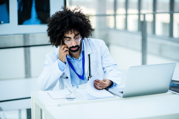 Portrait of thoughtful male doctor in hospital, corona virus concept.