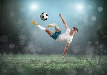 Wall Mural - Soccer player on a football field in dynamic action at summer da