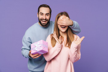 Wall Mural - Man covering eyes of his girlfriend holding gift box.