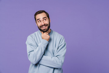 Wall Mural - Dreaming positive young man isolated over purple wall