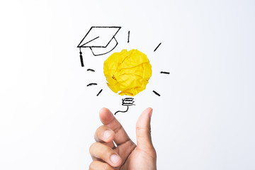 Wall Mural - Education, Creative idea, New idea and Innovation concept with Student hand holding crumpled yellow paper light bulb with graduation hat sketch icon