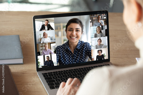 Cuadros en Lienzo Laptop screen over woman shoulder view, indian businesswoman leading videoconference distant communication group videocall conversation