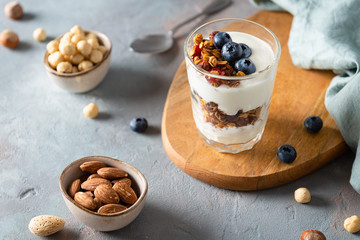 Wall Mural - Homemade granola with yogurt in a glass on gray background. Side view. Dieting, healthy breakfast, nutrition