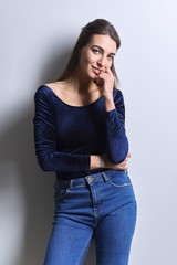 Wall Mural - Portrait of young woman looking at camera on white background