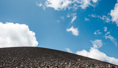 Tourists hiking up the black lava ash sand of Cerro Negro in order to volcano board back down - a popular excursion near Leon, Nicaragua