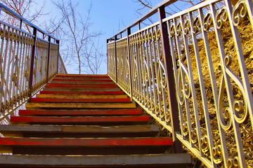 a pedestrian staircase pointing up against the sky where there are no people on the steps