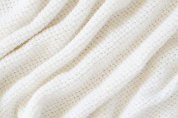 Beige knitted woolen background. Knitwear fabric texture.