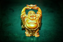 Laughing Buddha Golden Statue With Green Background