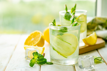 Summer lemonade in glasses in front of window, copy space