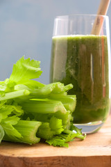 Wall Mural - Close-up of a glass with fresh vegetarian green smoothie of celery, spinach and apple. Healthy drink, snack. Vertical orientation