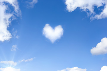 Beautiful blue sky with a white cloud in the shape of a heart. Natural background with a copy space