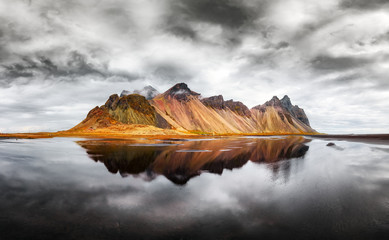 incredible landscape of the famous stokksnes mountains on vestrahorn cape. reflection in the clear w