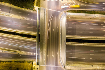 Beautiful night traffic junction road with lights of vehicle movement aerial view from drone.