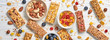 Cereal healthy snack. Granola bar with nuts and dry fruit berries. Diet food. Protein muesli bars isolated on wood background. Sport oatmeal bar, top view, closeup, banner