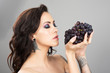 Face of a woman with blue grapes
