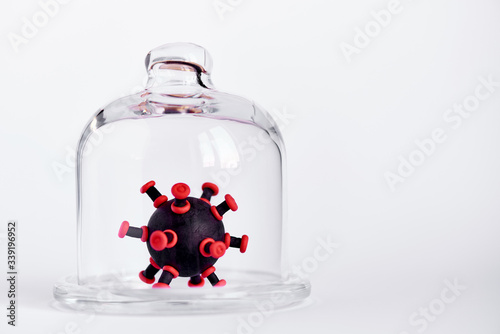 Cuadros en Lienzo Toy virus under a glass dome on a white background. Copy Space.