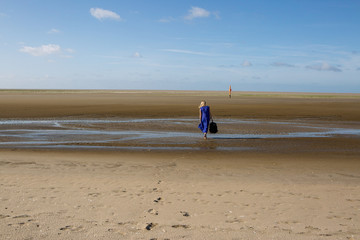 Fototapete - woman walks away on beach