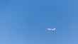 The plane flies in the clear blue sky. Cloudless blue sky over which the plane flies.