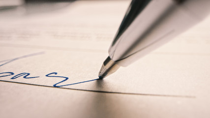 person signing important document. camera following tip of the pen as it signs crucial business cont