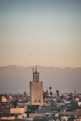 Sunset view of Koutoubia mosque in Marrakesh, Morocco with stork silhouette. Panoramic view of Marrakech with the old part of town Medina and minaret. Travel photo concept in summer.