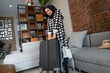 portrait of muslim woman carrying heavy suitcase. asian travelling