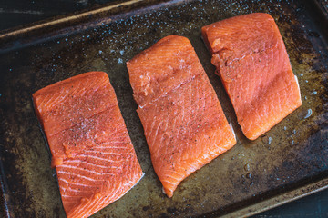 Wall Mural - Raw Salmon Fillets on a Sheet Pan: Salmon fillets seasoned with salt and pepper on a burnished sheet pan