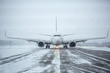 Airliner on runway in blizzard. Aircraft during taxiing during heavy snow. Passenger plane in snow at airport. Passenger airplane taxiing for take off at airport during snow blizzard