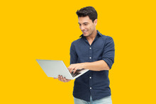 Portrait Of An Excited Man Holding Laptop Computer Isolated On Yellow Background, Feeling Happiness, Caucasian Male Model