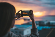 Woman Taking Photos Of The Sea From The Balcony With A Smartphone