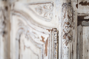 Wall Mural - Vintage chest of drawers with carving white color with fading and metal handle. Close-up. Selective focus