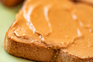 Wall Mural - Creamy peanut butter spread on healthy whole wheat toast bread