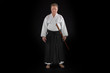 Portrait aikido master wearing traditional samurai hakama clothes with boken in hands. on black Background