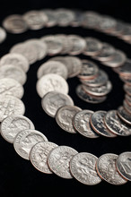 A Group Of American Dimes Form A Spiral On A Black Background. 