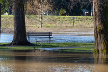 A Park Bench Surrounded By Flood Water