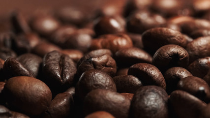 closeup of brown Roasted coffee beans in a black background.