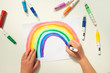 Top view of a boy drawing a rainbow