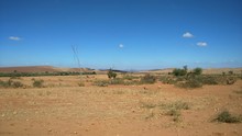 Scenic View Of Arid Landscape Against Blue Sky On Sunny Day