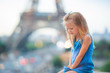 Adorable toddler girl in Paris background the Eiffel tower during summer vacation