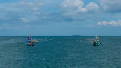 Two traditional Thai fishing boats with outriggers out