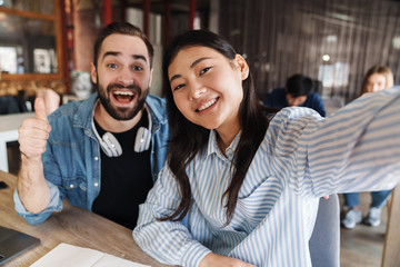 Poster - Photo of students gesturing thumb up and smiling while taking selfie