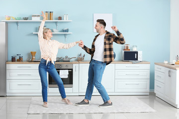 Canvas Print - Happy dancing young couple in kitchen