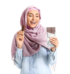 Sticker - Beautiful Muslim woman eating tasty chocolate on white background