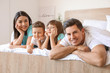 © Pixel-Shot - Happy family in bedroom at home