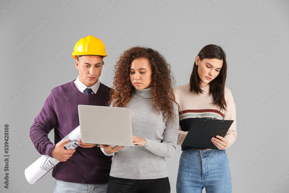 Young architects on grey background
