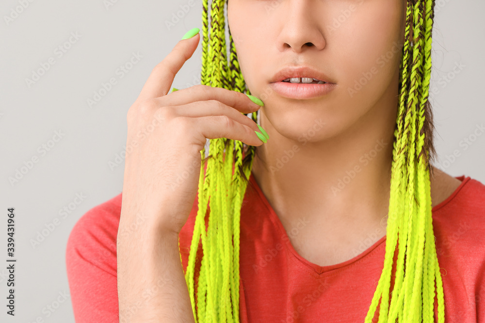 Young transgender woman on light background, closeup