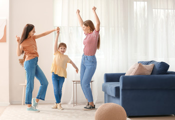 Wall Mural - Happy lesbian couple with little adopted girl dancing at home