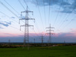 © Alexander - Pylons of a  high-voltage power on a sunset. Electrical industry.