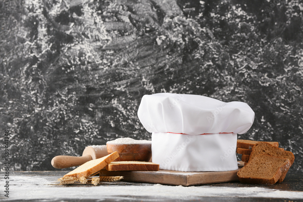 Composition with chef's hat on table against grunge background
