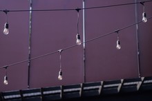 Light Bulbs Hang On The Wall And Ceiling In The Garden.